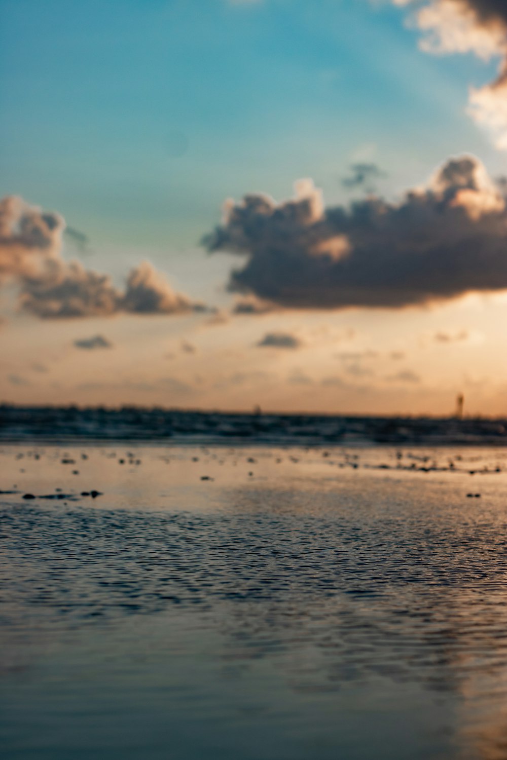 body of water under white clouds and blue sky during daytime