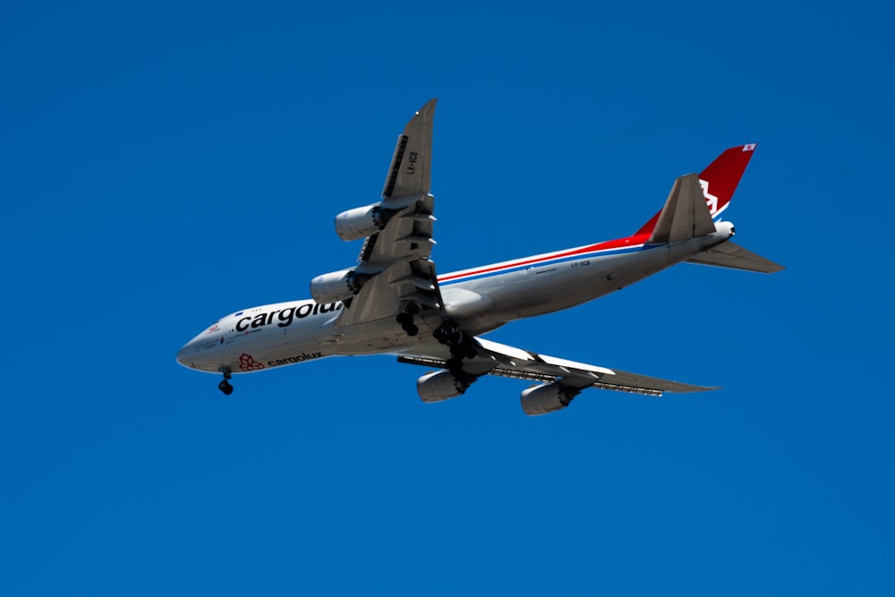 avion blanc et rouge en plein vol pendant la journée