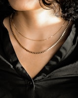 person wearing silver chain necklace