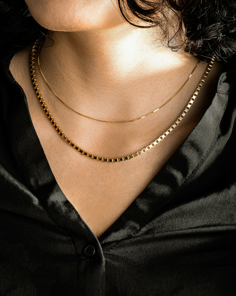 person wearing silver chain necklace