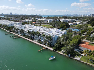white and blue boat on water near city buildings during daytime