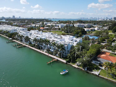 white and blue boat on water near city buildings during daytime