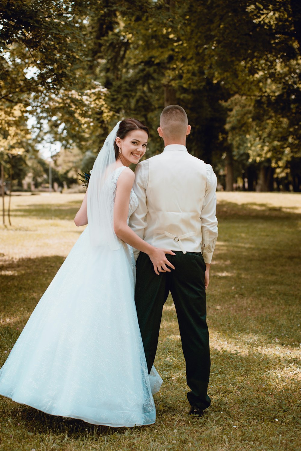 man in white dress shirt and black pants holding woman in white wedding dress