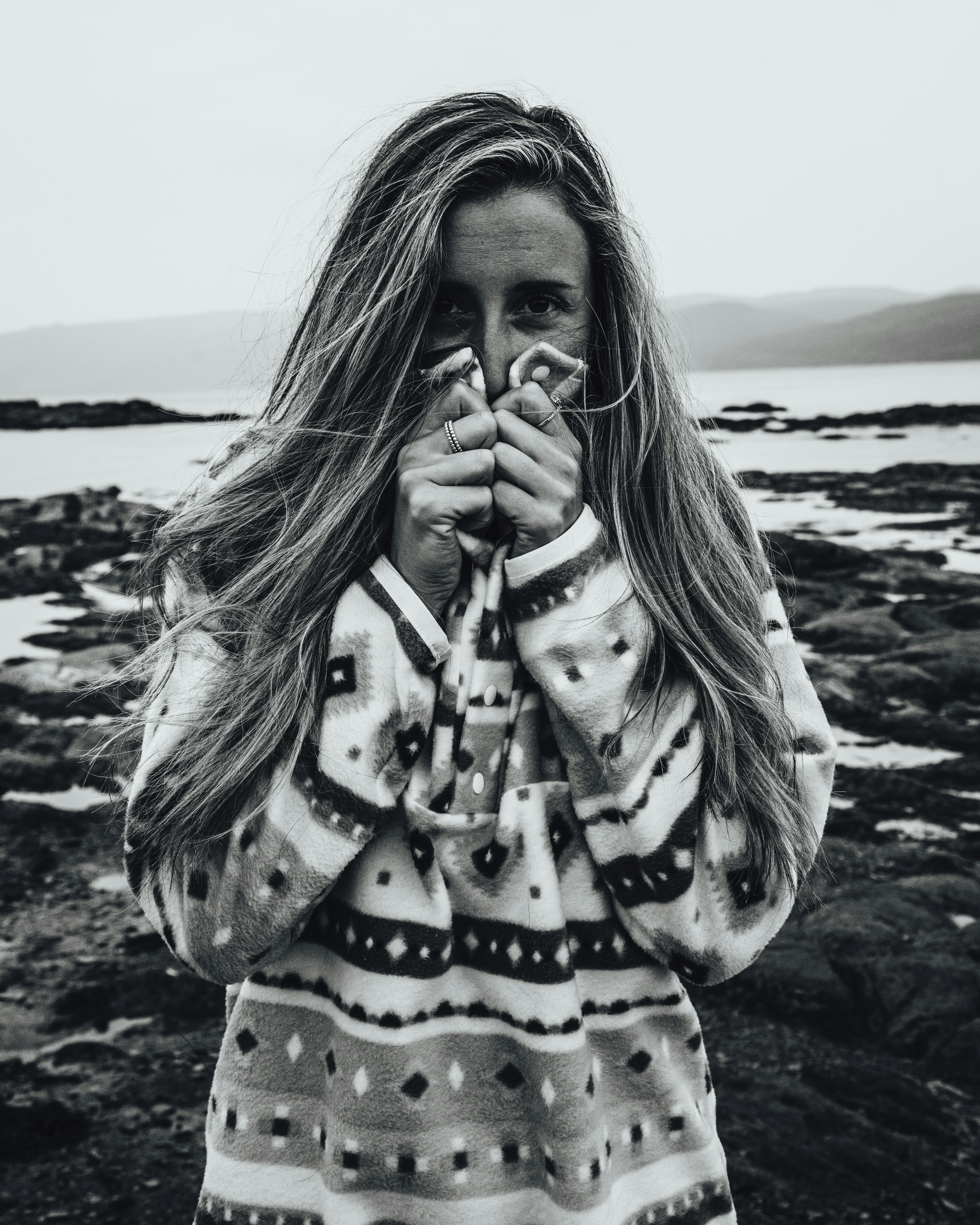 woman in black and white polka dot long sleeve shirt standing on seashore
