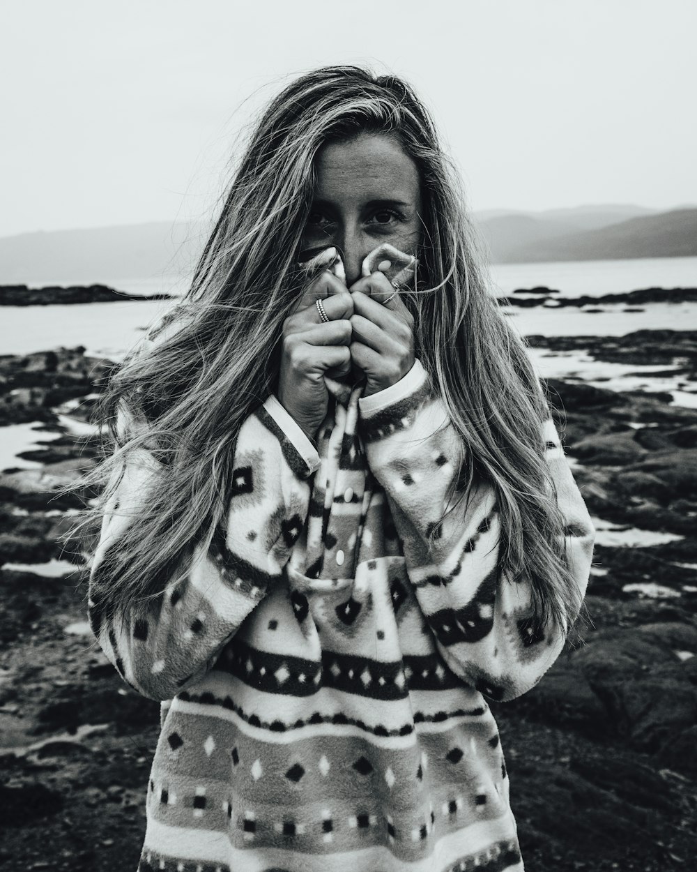 woman in black and white polka dot long sleeve shirt standing on seashore