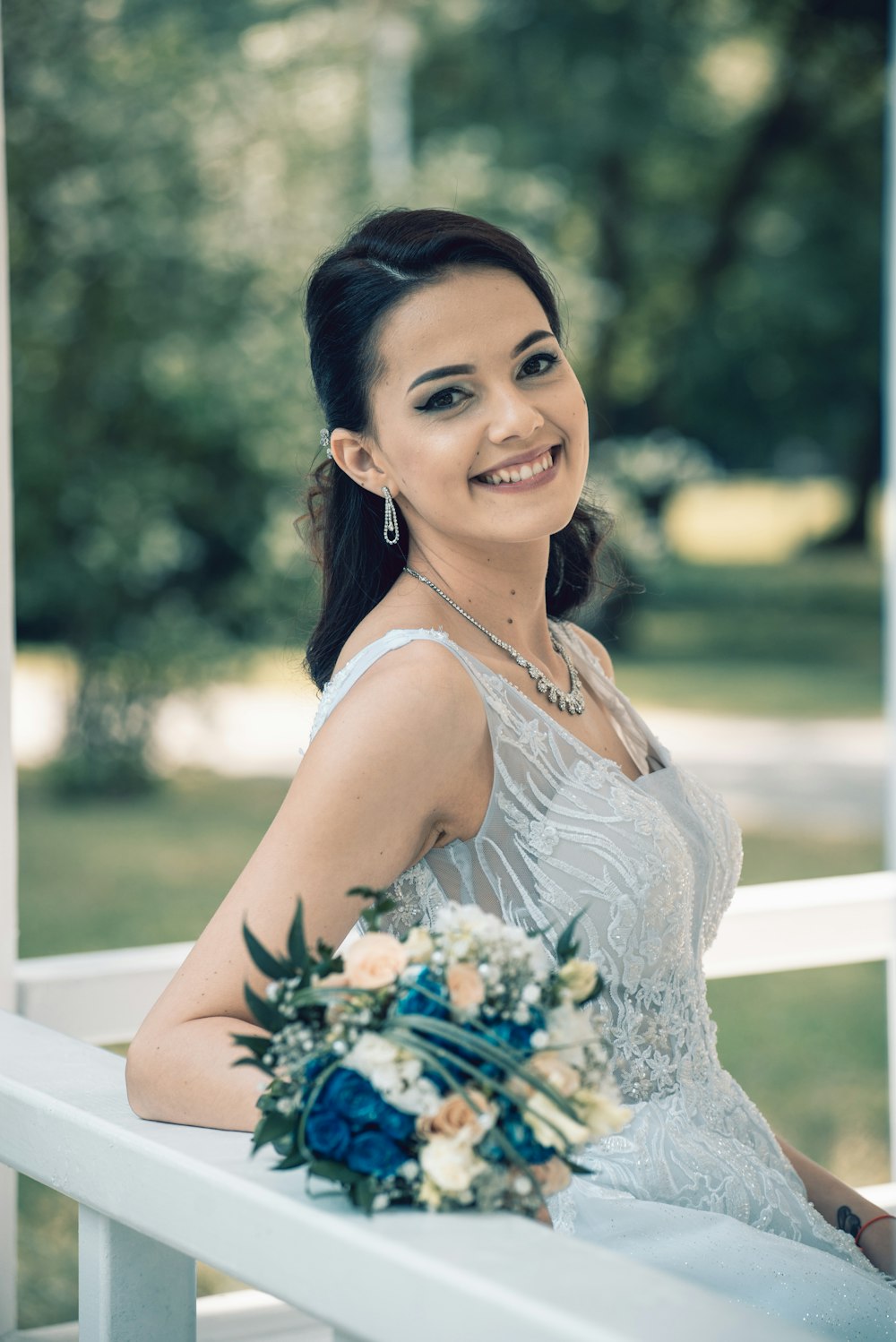 woman in white spaghetti strap dress holding bouquet of flowers