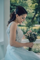 woman in white floral dress holding bouquet of flowers