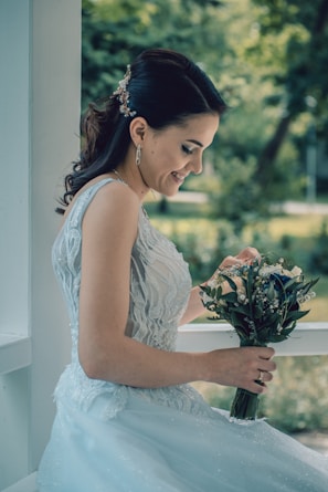 woman in white floral dress holding bouquet of flowers