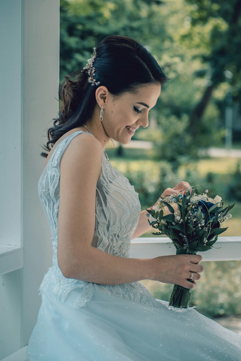 woman in white floral dress holding bouquet of flowers