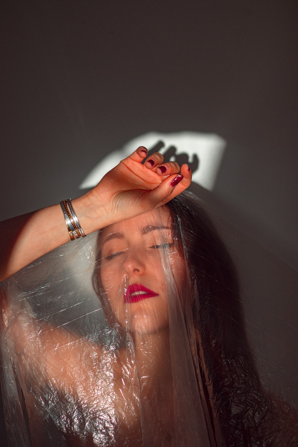 woman in black manicure holding clear plastic bag