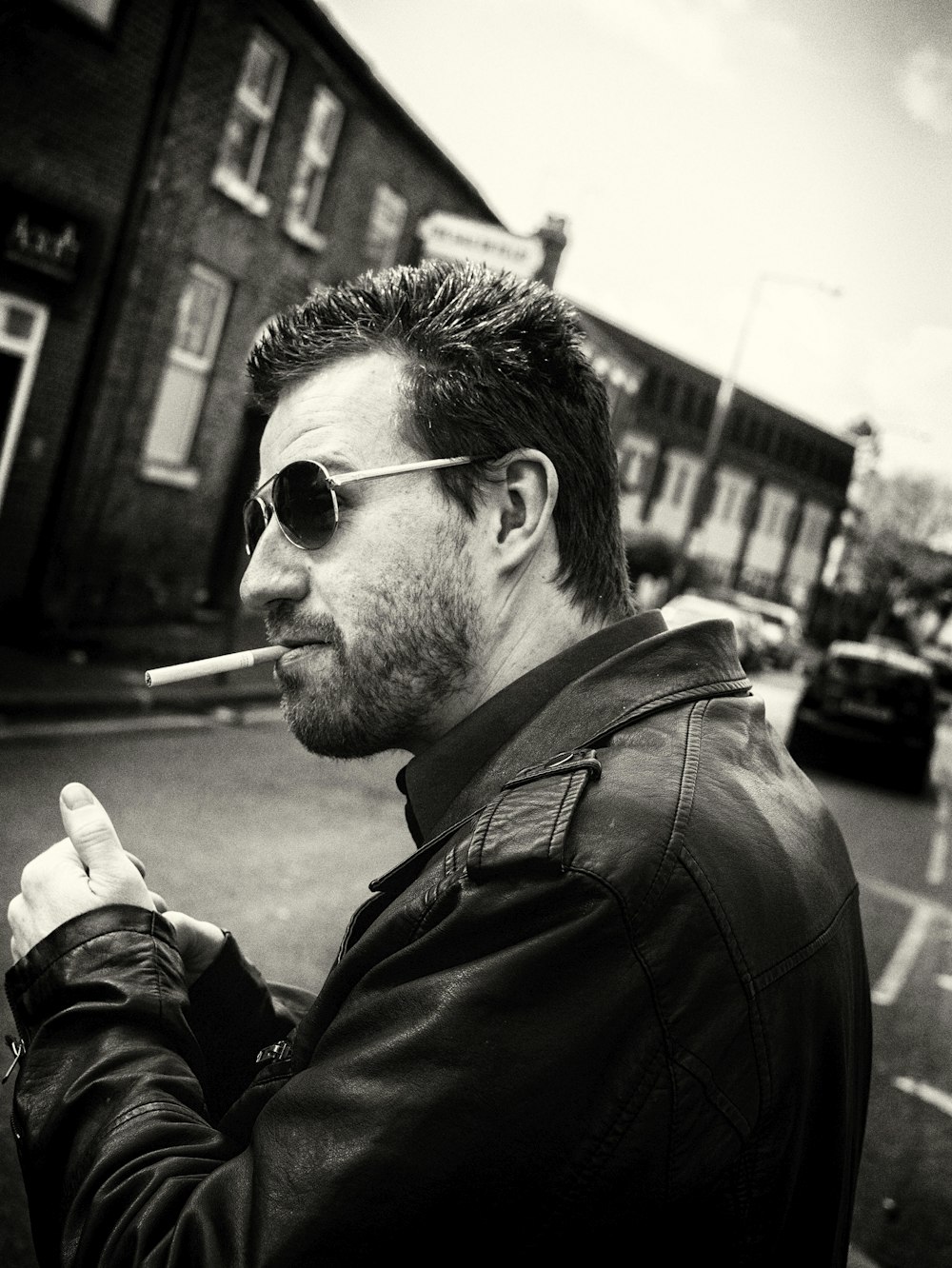 man smoking cigarette in grayscale photography