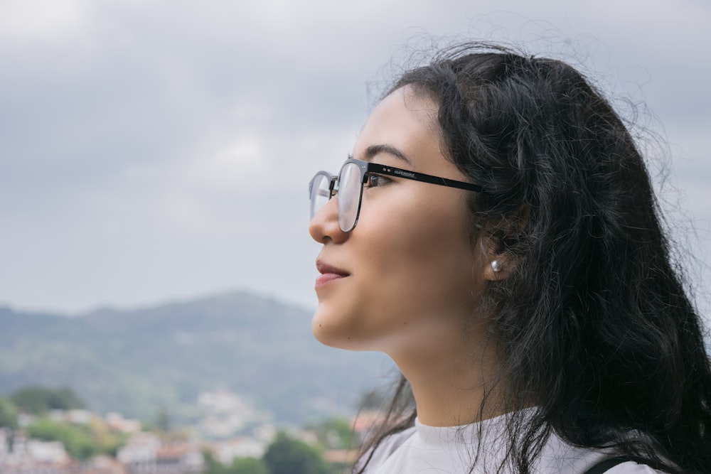 woman in white crew neck shirt wearing black framed eyeglasses