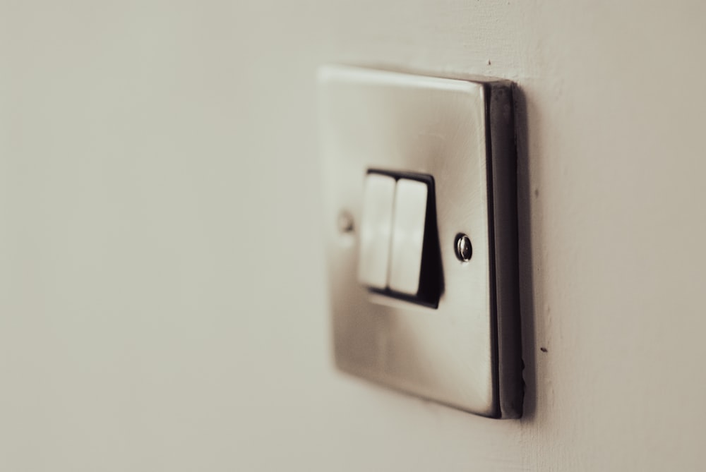 Interruptor de luz blanca en la pared pintada de blanco