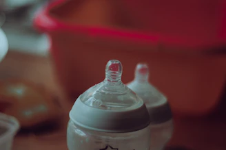 clear plastic feeding bottle on red table