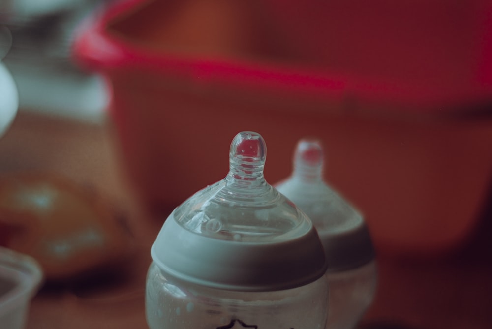 clear plastic feeding bottle on red table