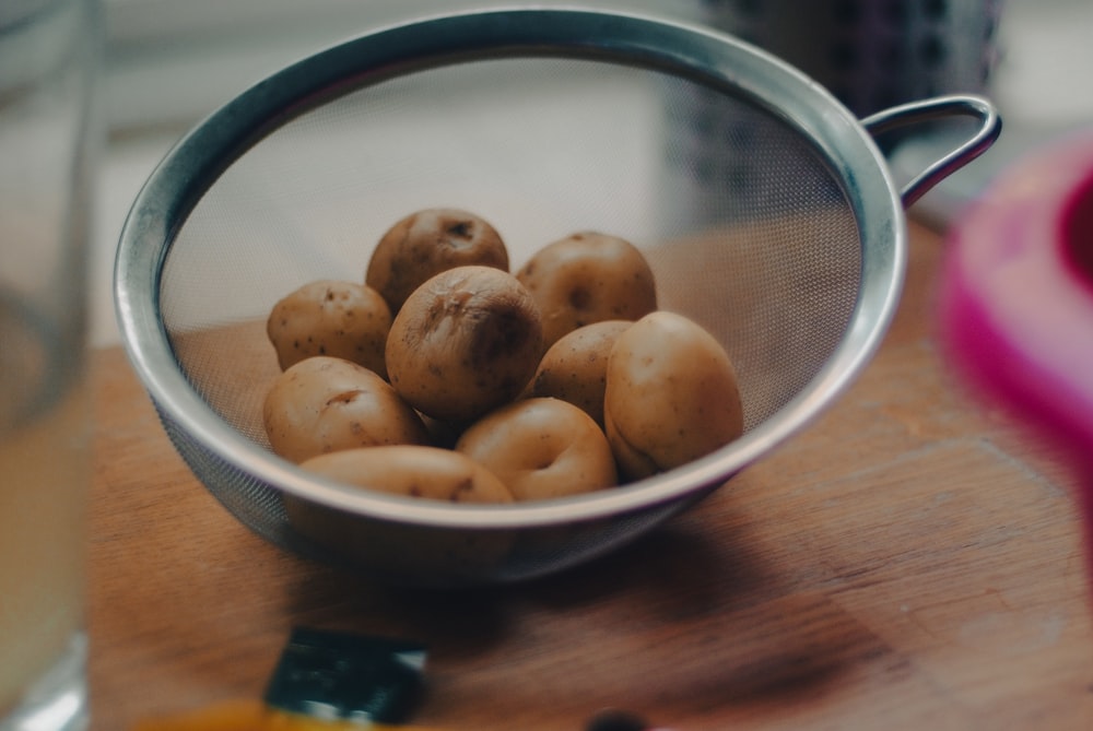 brown round fruits on white ceramic bowl