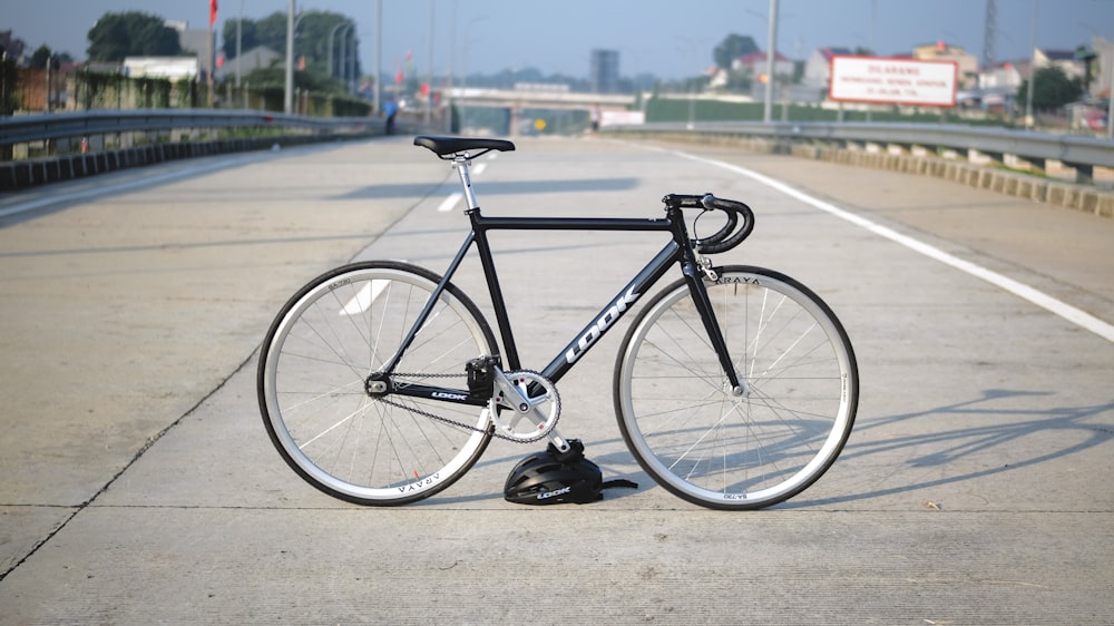 black and gray road bike on gray concrete road during daytime