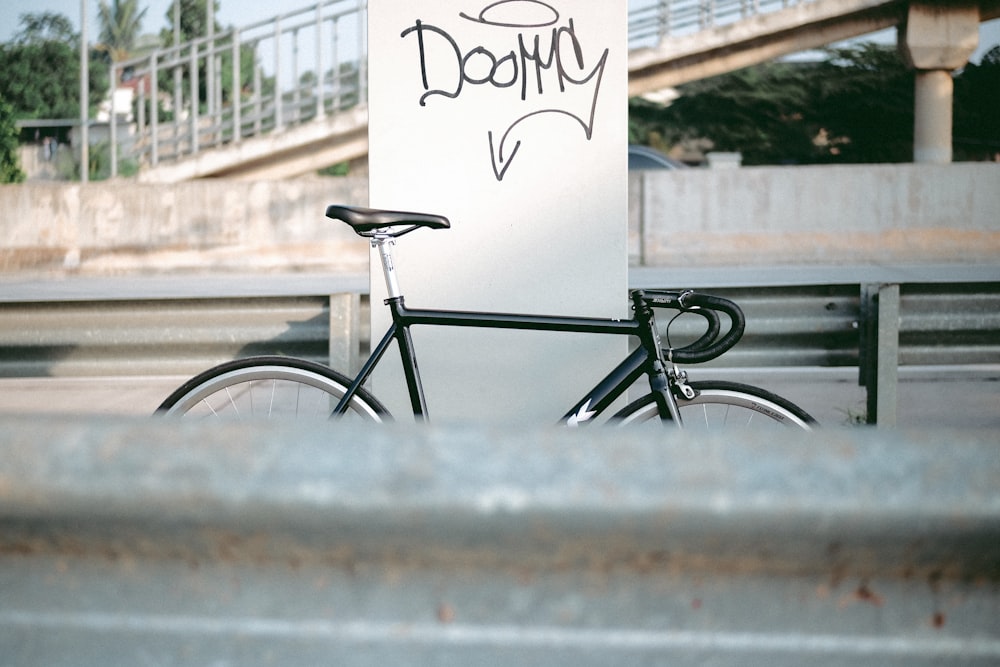 black city bike parked beside white wall