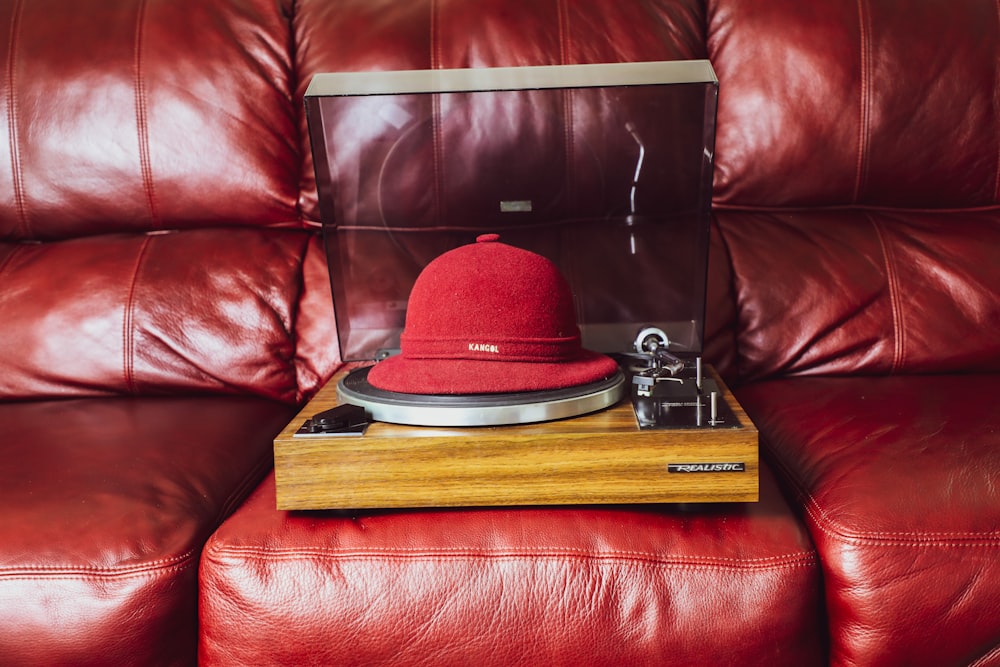 sombrero rojo y negro sobre mesa de madera marrón