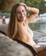 woman in white sleeveless dress leaning on brown wooden railings