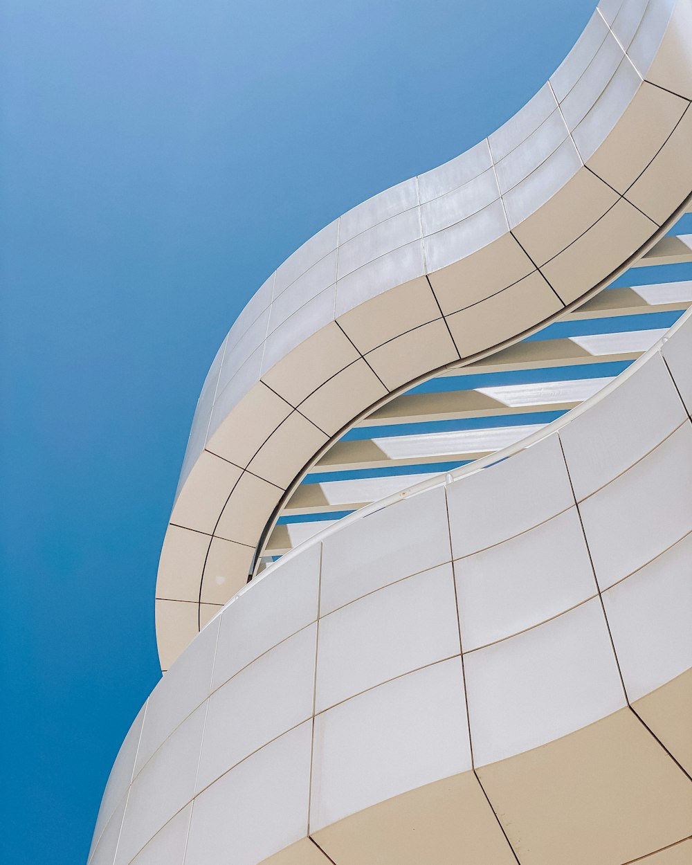 Weißes Betongebäude unter blauem Himmel tagsüber