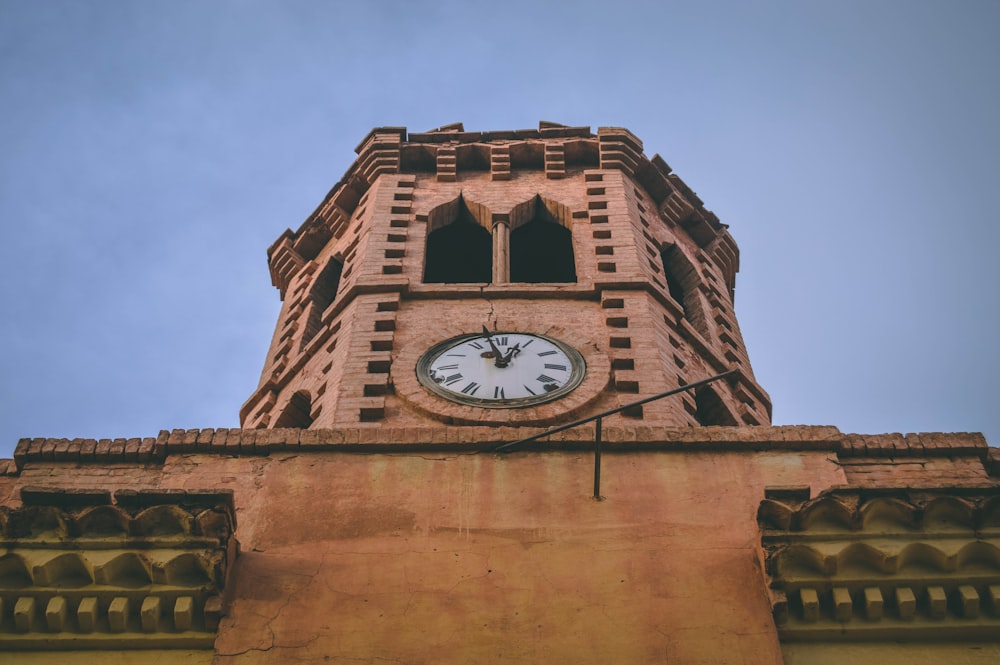 brown concrete building with analog clock