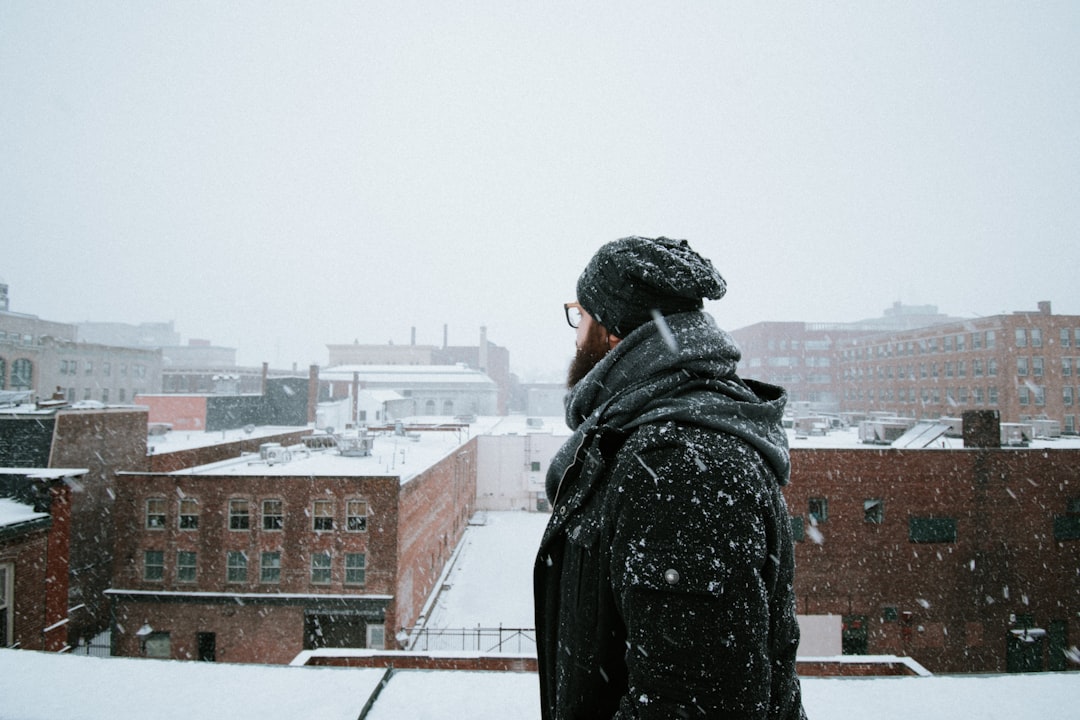 person in black jacket standing on roof top during daytime