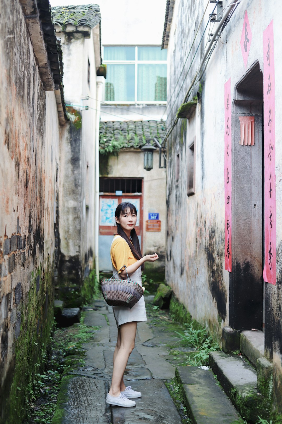 woman in yellow shirt and white skirt sitting on concrete wall