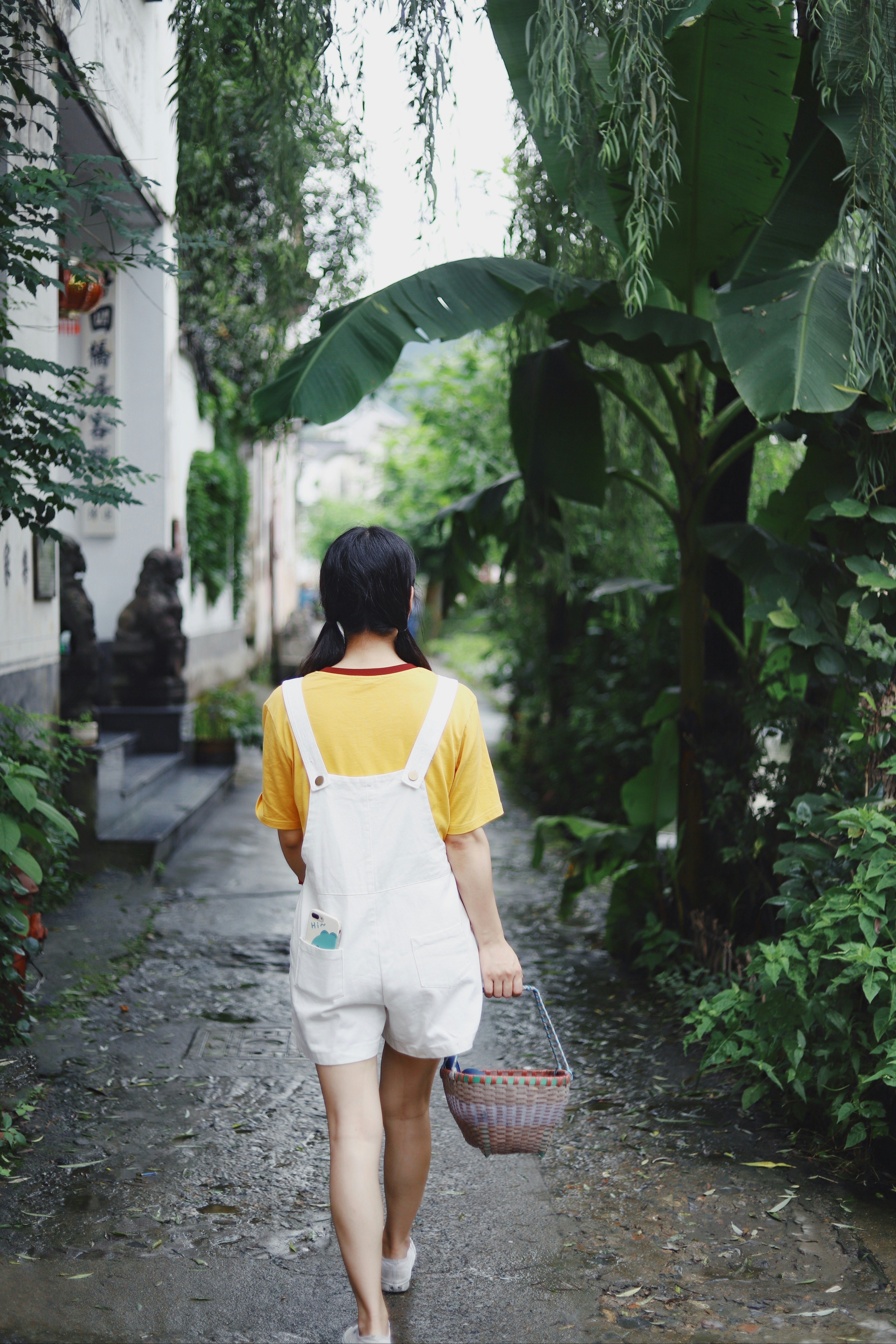 woman in white and yellow shirt walking on pathway
