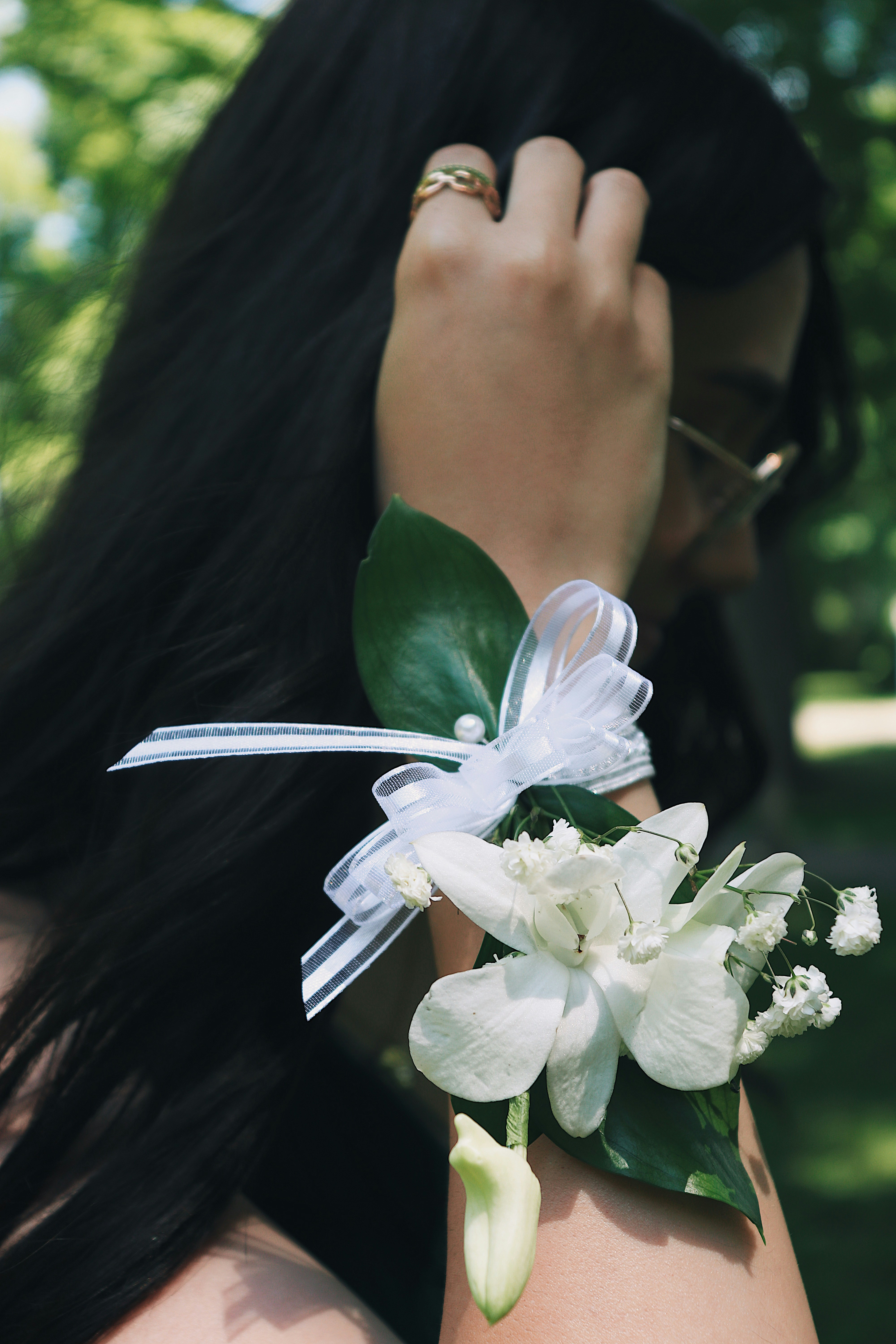 woman in green shirt holding white flower