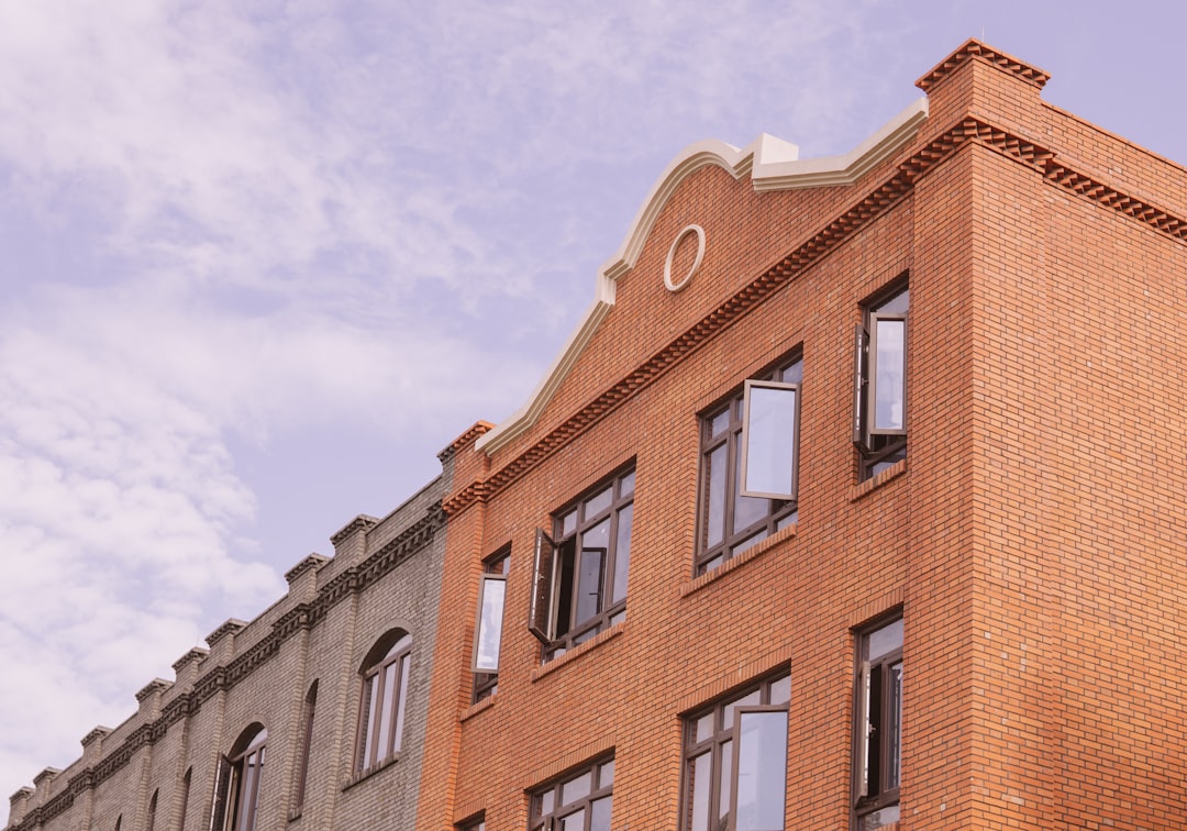 brown concrete building under white clouds during daytime