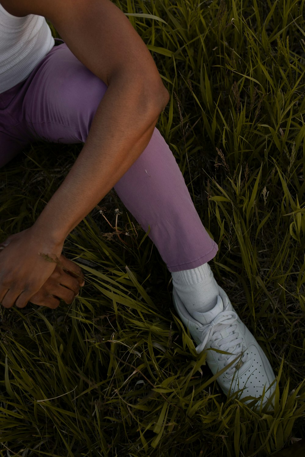 a person sitting in the grass with their shoes on