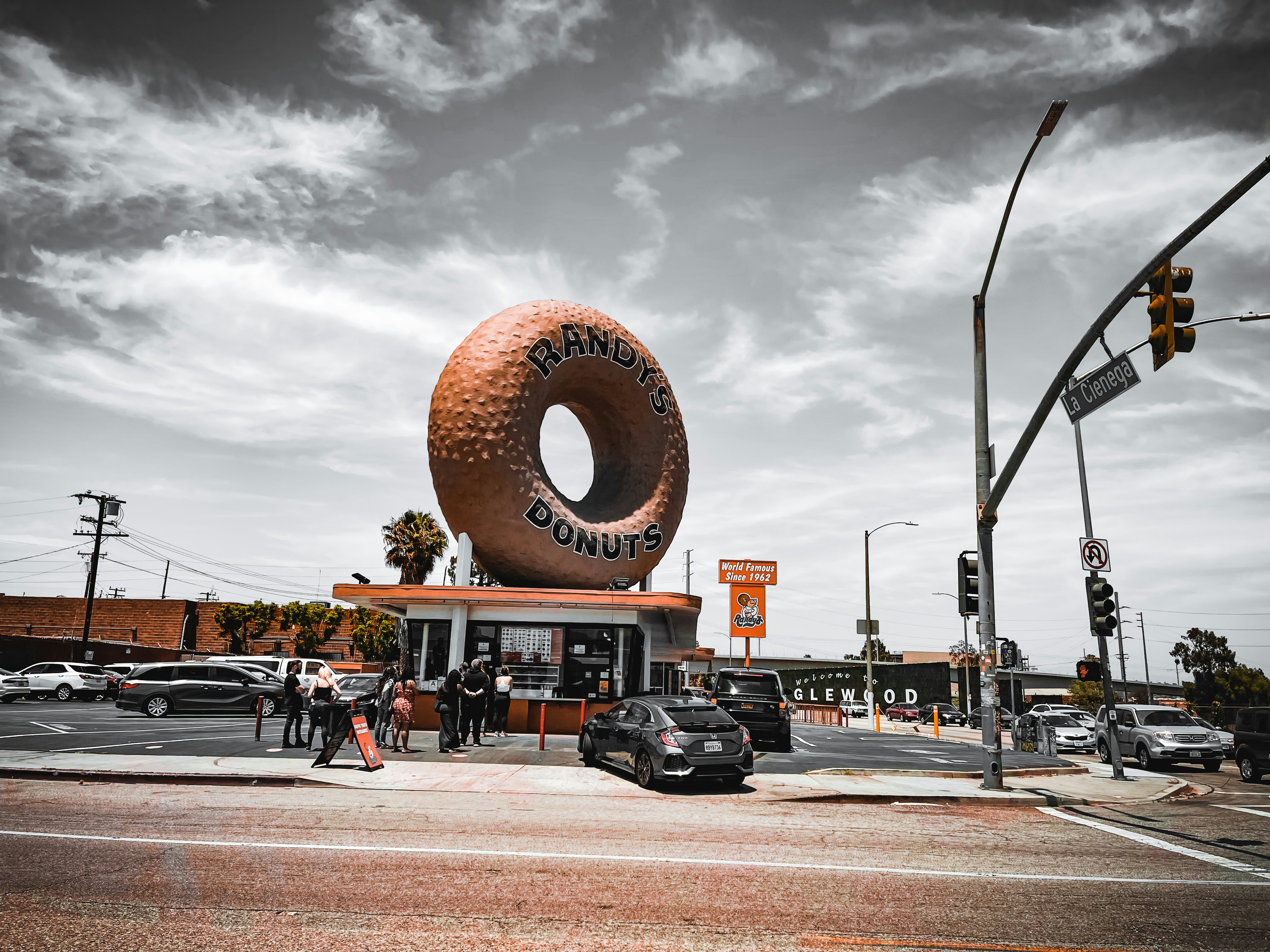 black car parked near brown and white mushroom statue during daytime