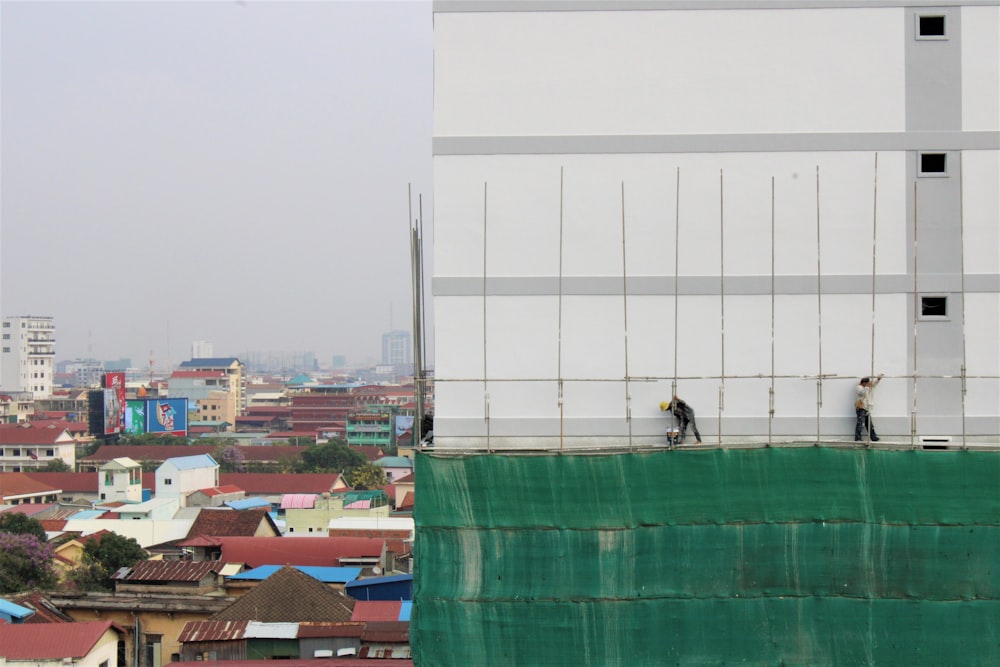 person in black shirt sitting on roof top during daytime