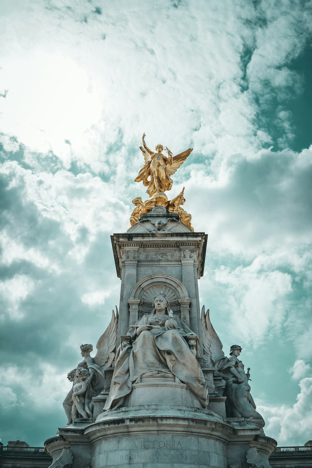 Estatua de oro bajo el cielo nublado durante el día