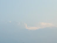 A tranquil window view of gentle clouds drifting by on a sunny day.