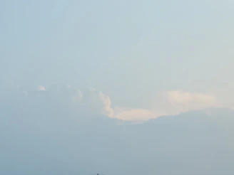 A tranquil window view of gentle clouds drifting by on a sunny day.