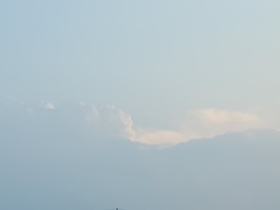 A soft blue sky with gentle white clouds drifting peacefully.