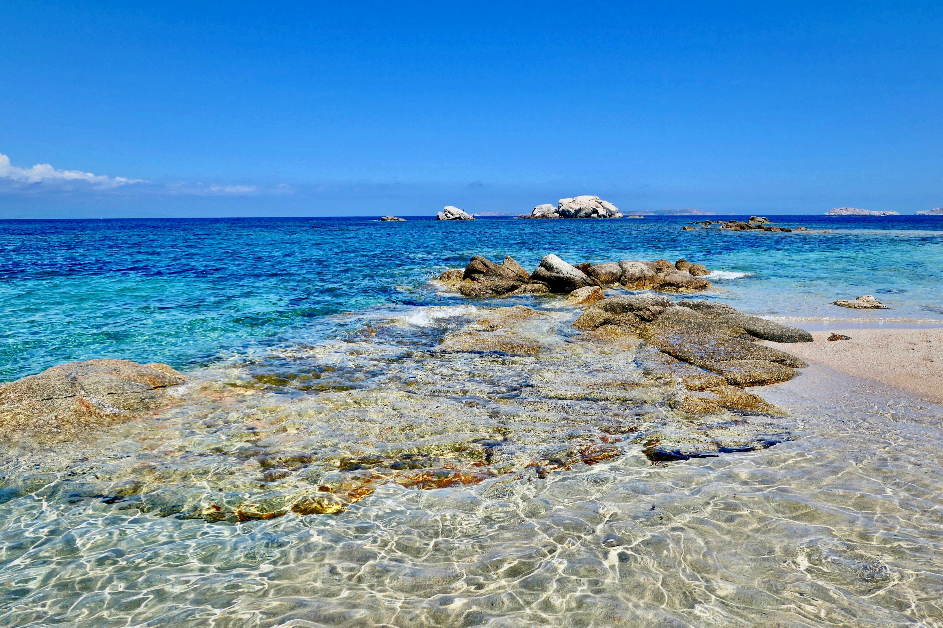 brown rocks on sea shore under blue sky during daytime