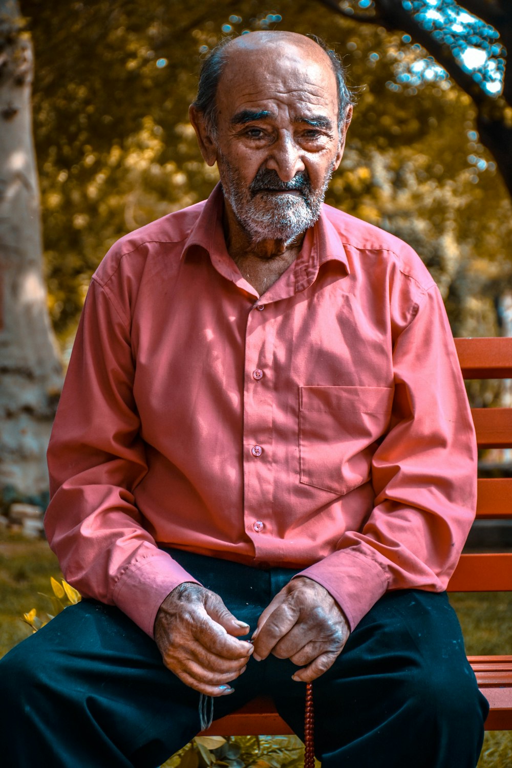man in brown dress shirt sitting on brown wooden bench during daytime