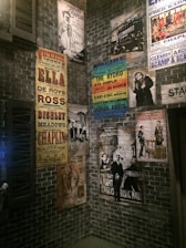A creative gallery wall filled with photos and posters from past stand up comedy events.