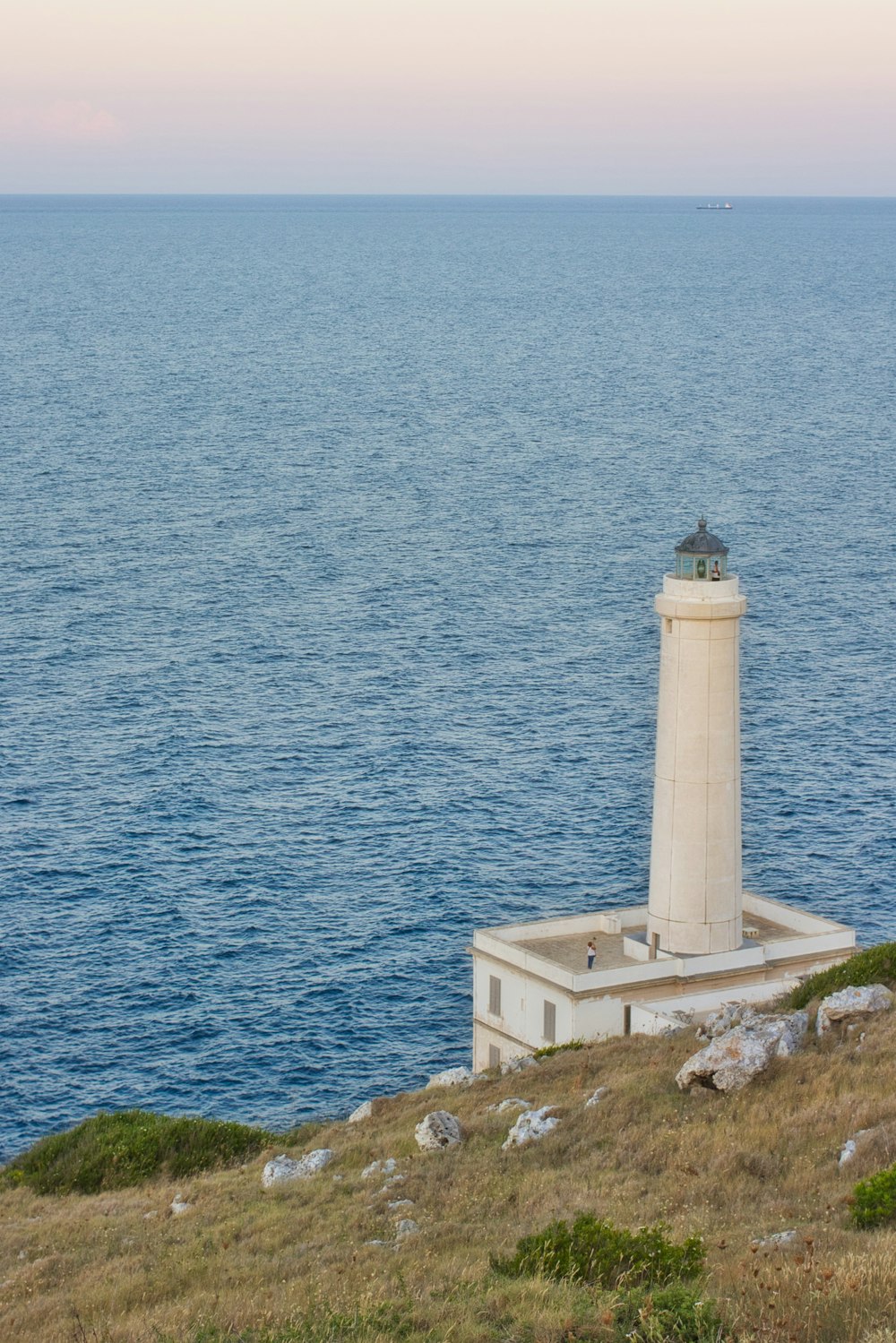 white lighthouse near body of water during daytime