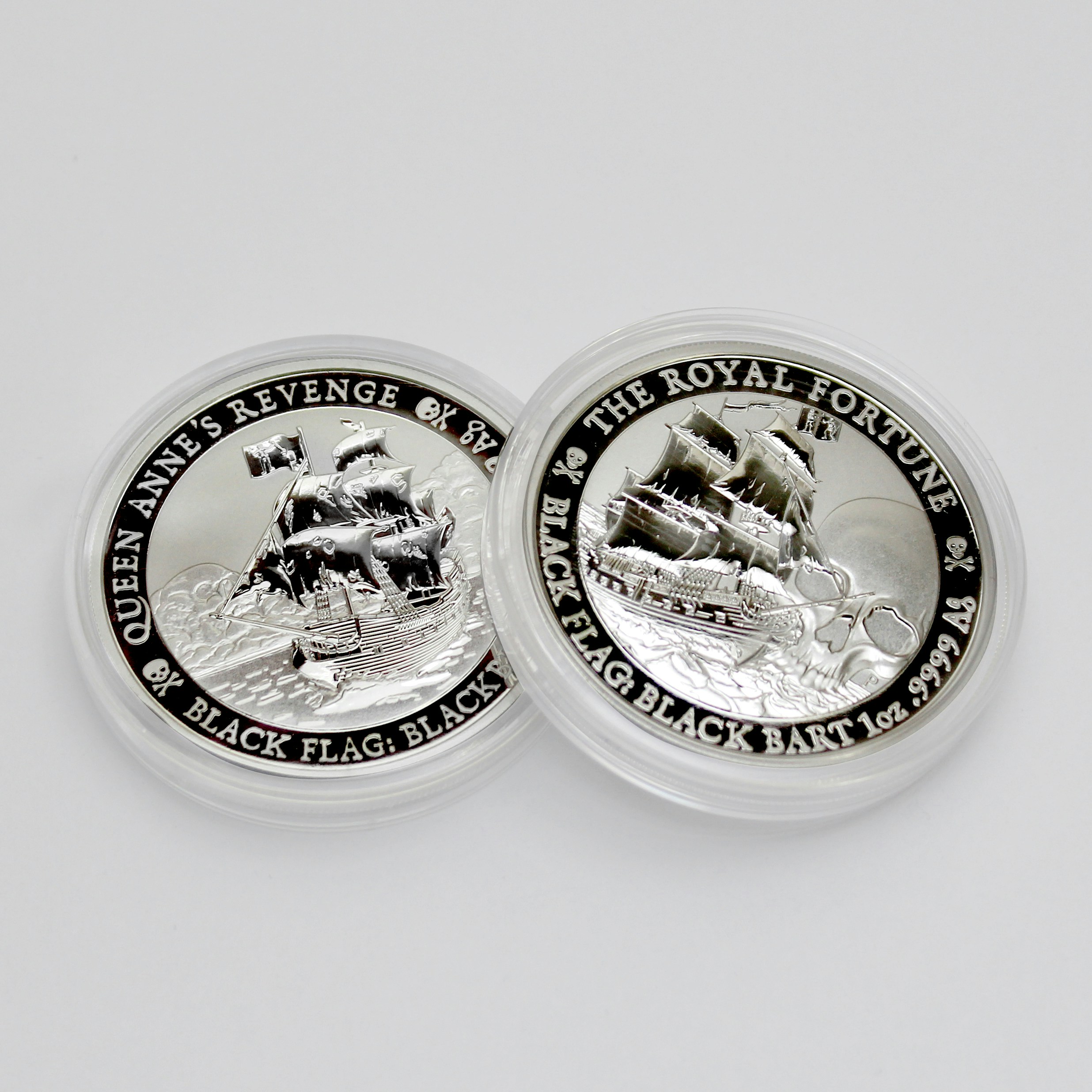 2 round silver coins on white surface