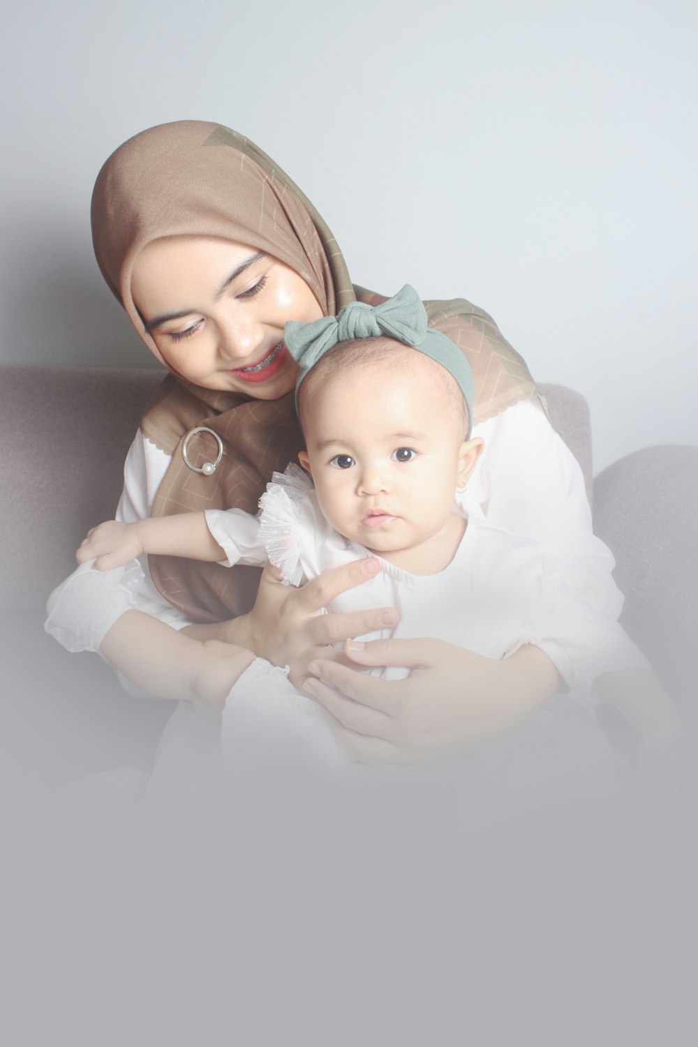 woman in white hijab carrying baby
