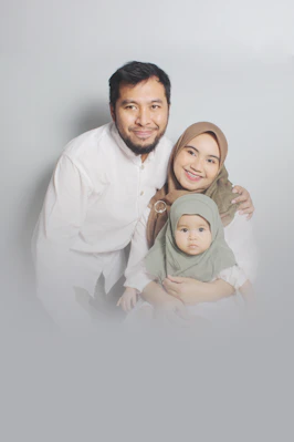man in white dress shirt carrying girl in green dress