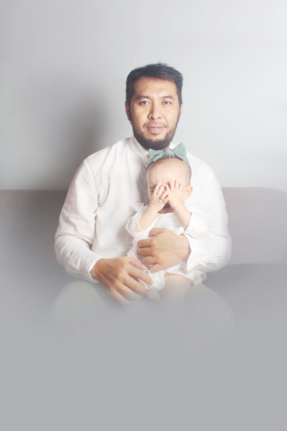 man in white dress shirt holding baby