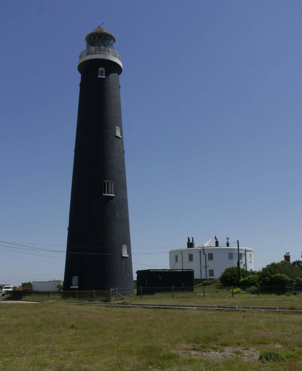 Faro blanco y negro bajo el cielo azul durante el día