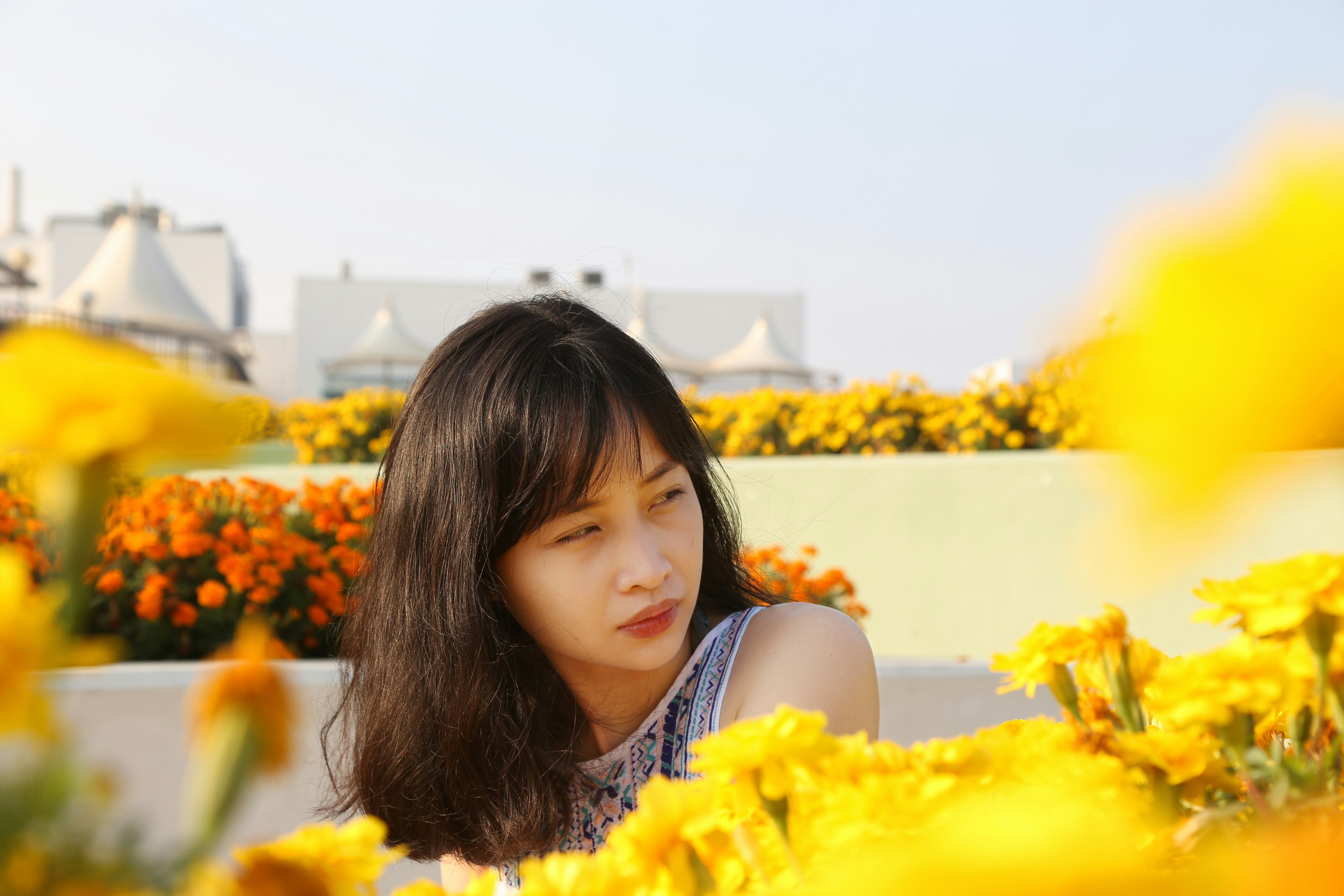 girl in black tank top standing on yellow flower field during daytime