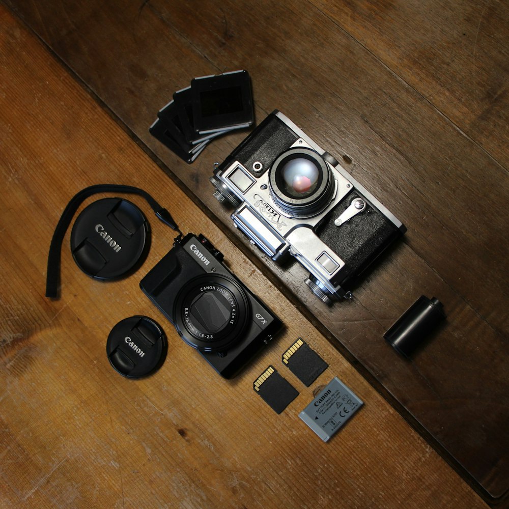 Cámara DSLR negra y plateada sobre mesa de madera marrón