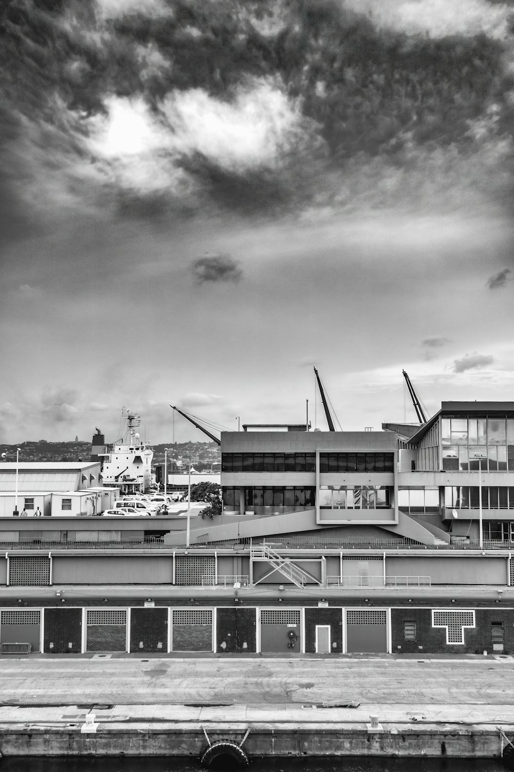 grayscale photo of building under cloudy sky